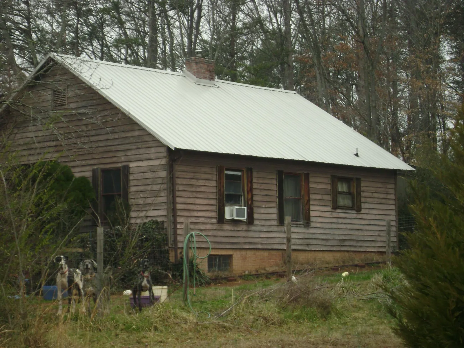 White metal roof on an old wood sided farmhouse, from a Metal Roof Installation job in Rawlings
